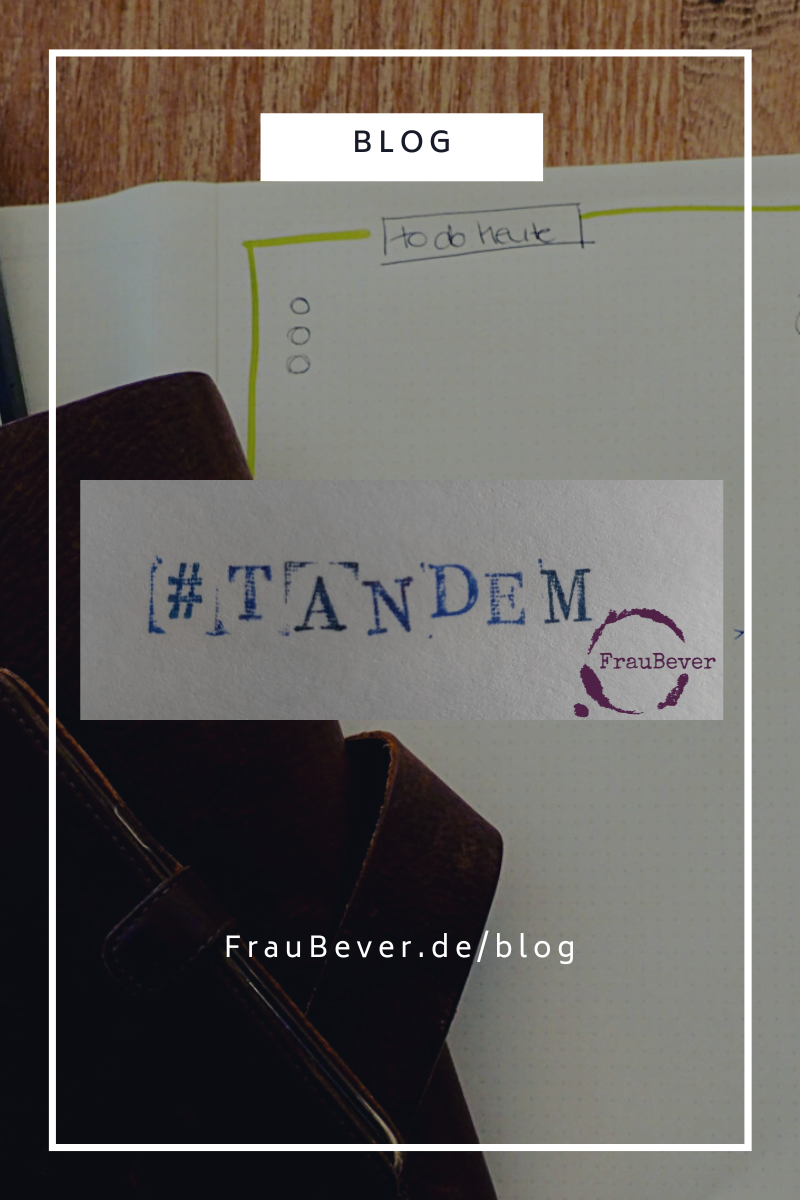 Schriftzug "Tandem", gestempelt. Beitragsbild für Blogpost "Vereinbarkeit ist mehr als Kinder", Kalender und Notizblock im Hintergrund